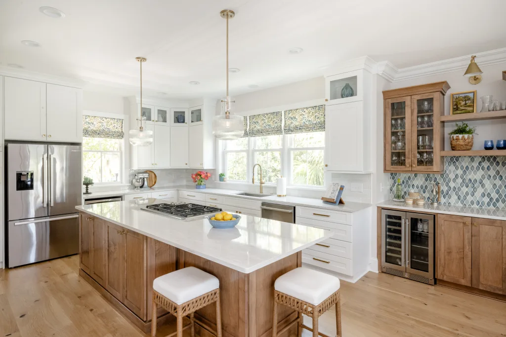 Open-concept kitchen with wood island and white cabinetry by Charleston designer Ryan-Marie