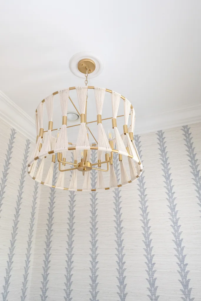 Brass and rope chandelier close-up with botanical striped wallpaper in Charleston, SC